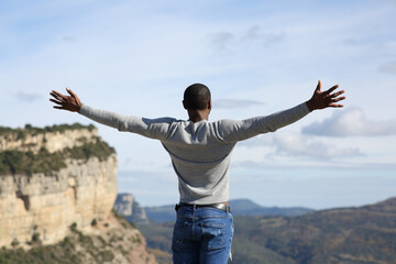 Man with black skin celebrating in the mountain