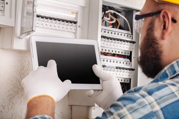 An engineer or electrician worker working check the electrical system with tablet