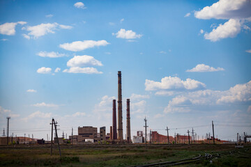 Silhouette of electric power plant on blue sky with clouds. Railroad on foreground. Industrial zone of Arkalyk, Kazakhstan.