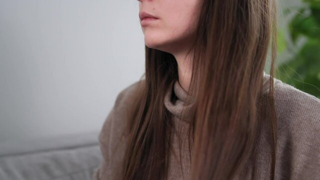 hair care, young girl combing her long healthy hair with a comb while sitting on couch at home
