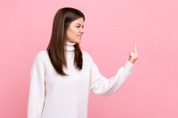 Side view portrait of aggressive woman standing and shows fuck sign, expressing negative emotions,...