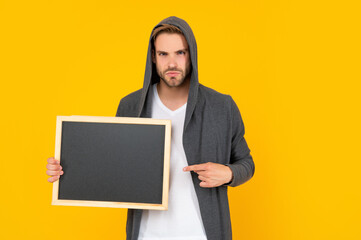 man presenting advertisement with copy space on yellow background, advertisement