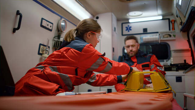 Team paramedics getting ready for patient resuscitation in emergency vehicle