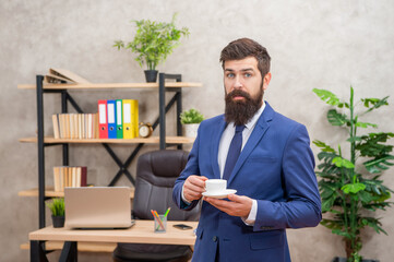 amazed brutal ceo in businesslike suit hold morning coffee cup at the office, coffee break