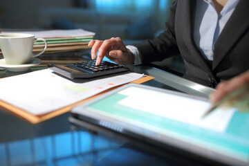 Businesswoman hand accounting using calculator and tablet