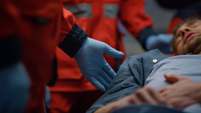 Patient lying on stretchers in ambulance car. Tired man having pain in stomach