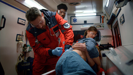 Emergency medical doctors giving first aid for victim in emergency car. © stockbusters