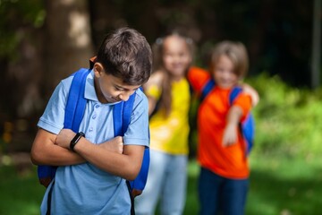 Naklejka premium Upset school girl on classmates background