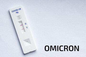 a positive rapid test for coronavirus on a white background and the inscription Omicron, copy space