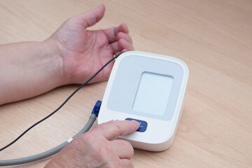 A device for measuring blood pressure.An elderly woman measures blood pressure at home.