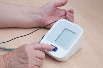 A device for measuring blood pressure.An elderly woman measures blood pressure at home.