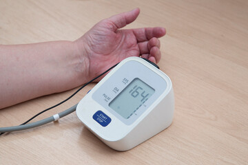 A device for measuring blood pressure.An elderly woman measures blood pressure at home.