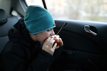 Child eating burger in car