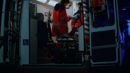 Fototapeta na wymiar Emergency doctors reanimating patient with defibrillator in ambulance car