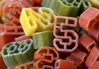 food for children. tricolor pasta. multicolored pasta shaped numbers texture background. close up