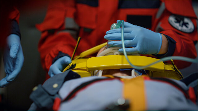 Team of paramedics providing first aid help for injured patient in ambulance car
