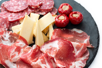 Vassoio di deliziosi antipasti italiani con capocollo, salame, formaggio vaccino e peperoncini ripieni 