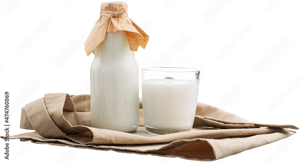 Poster Fresh organic milk in glass and jug on rustic wooden table on nature background.