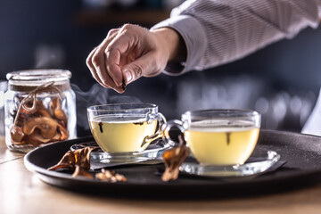 Detail of a bartender's hand flavoring Hot Teddy whiskey drink with cloves
