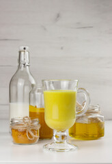 A glass of golden milk, ayurvedic turmeric beverage and ingredients