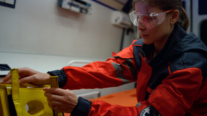 Serious ambulance paramedic getting ready neck immobilizer in emergency vehicle