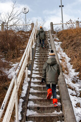 Dwójka dzieci wspinająca się po schodach zimą