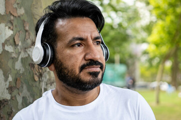 portrait Latin man with headphones listening to music