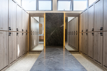 Changing rooms with wooden cabinets, mirror with light and marble benches