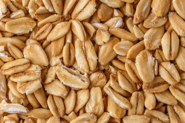 Rolled oat, oat flakes background or texture. Close up, directly above.Heap of dry rolled oats isolated.