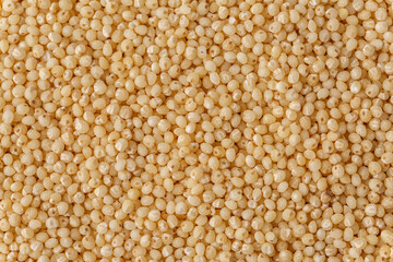 Macro photo couscous. Yellow grains of wheat grits, cuscus, semolina, universal porridge for breakfast.Background texture of couscous grains. Top view.