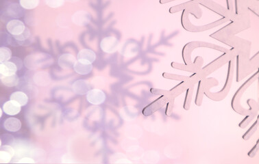 Winter background: part of a decorative snowflake, its shadow on a pastel background, bokeh, space for text