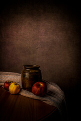 Still life with old water jar and three apples and a cloth on table. Art and oil paintings concept. With copy space.