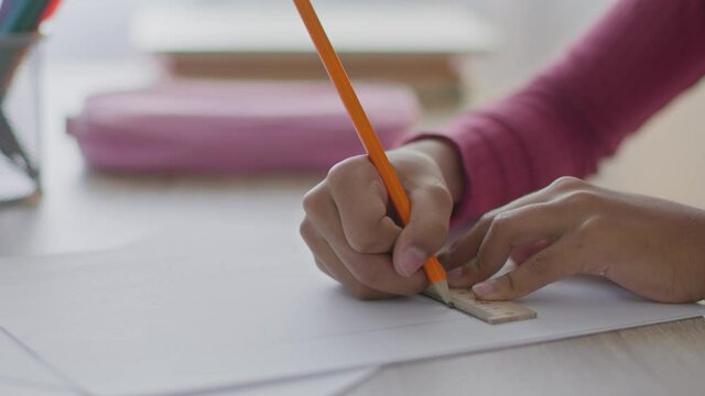 Geometry task. Close up shot of unrecognizable black girl drawing straight line with pencil and ruler, doing homework