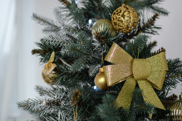 toys hang on the branches of a Christmas tree against the background of flickering garlands. New...