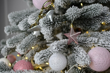 toys hang on the branches of a Christmas tree against the background of flickering garlands. New year concept.