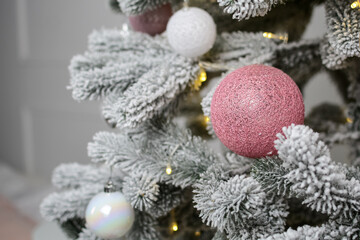 toys hang on the branches of a Christmas tree against the background of flickering garlands. New year concept.