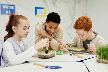 Portrait of diverse group of children experimenting with plants in biology class