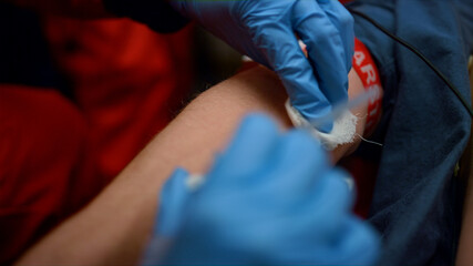 Closeup emergency doctor preparing patient hand for blood test