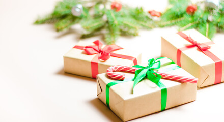 Handmade gifts decorated with colorful ribbons on a background decorated with fir branches. Blurry, defocused, selective focus. Copy space
