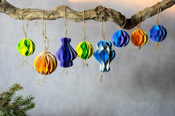 Scandinavian Christmas decorations made with their own hands hang on a dried branch in a row. A modern trend, plastic free, copy space.
