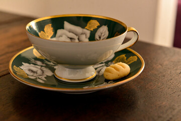 green porcelain coffee cup with biscuit on the saucer, luxury porcelain cup, coffee shop, breakfast