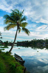 A wooden boat under a coconut tree, Riverside photography, Kerala Backwaters, Kerala backwaters photography during day time Kadamakkudy Kerala
