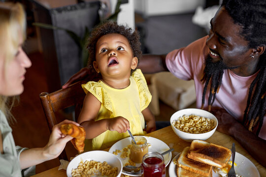 Child Having Breakfast. Kid Eating Poridge With Fruit. Little Girl At Dining Table In Kitchen With Diverse Parents. Kids Eat On Sunny Morning. Healthy Balanced Nutrition For Young Kids. Children