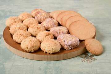 Three types of homemade cookies on a board. Turquoise background.