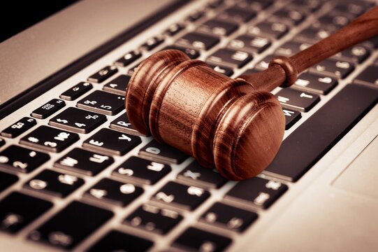 Gavel placed on laptop pc. Company known for its surveillance software.