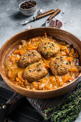 Cutlets or Fish balls with tuna in tomato sauce. Gray background. Top view