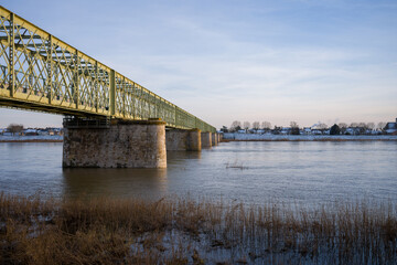 The Loire under the pedestrian bridge of Sully sur Loire under the snow in Europe, in France, in the Center region, in the Loiret, towards Orleans, in Winter, during a sunny day.
