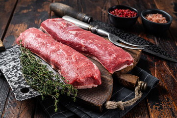 Raw lamb tenderloin fillet, Mutton fresh meat on butcher wooden board. Wooden background. Top view