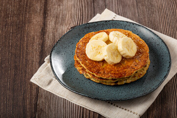 Banana oat pancakes topped with sliced ​​bananas and honey.