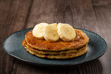 Banana oat pancakes topped with sliced ​​bananas and honey.